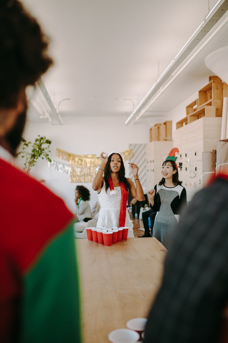 A Woman Playing Beer Pong During Christmas Party