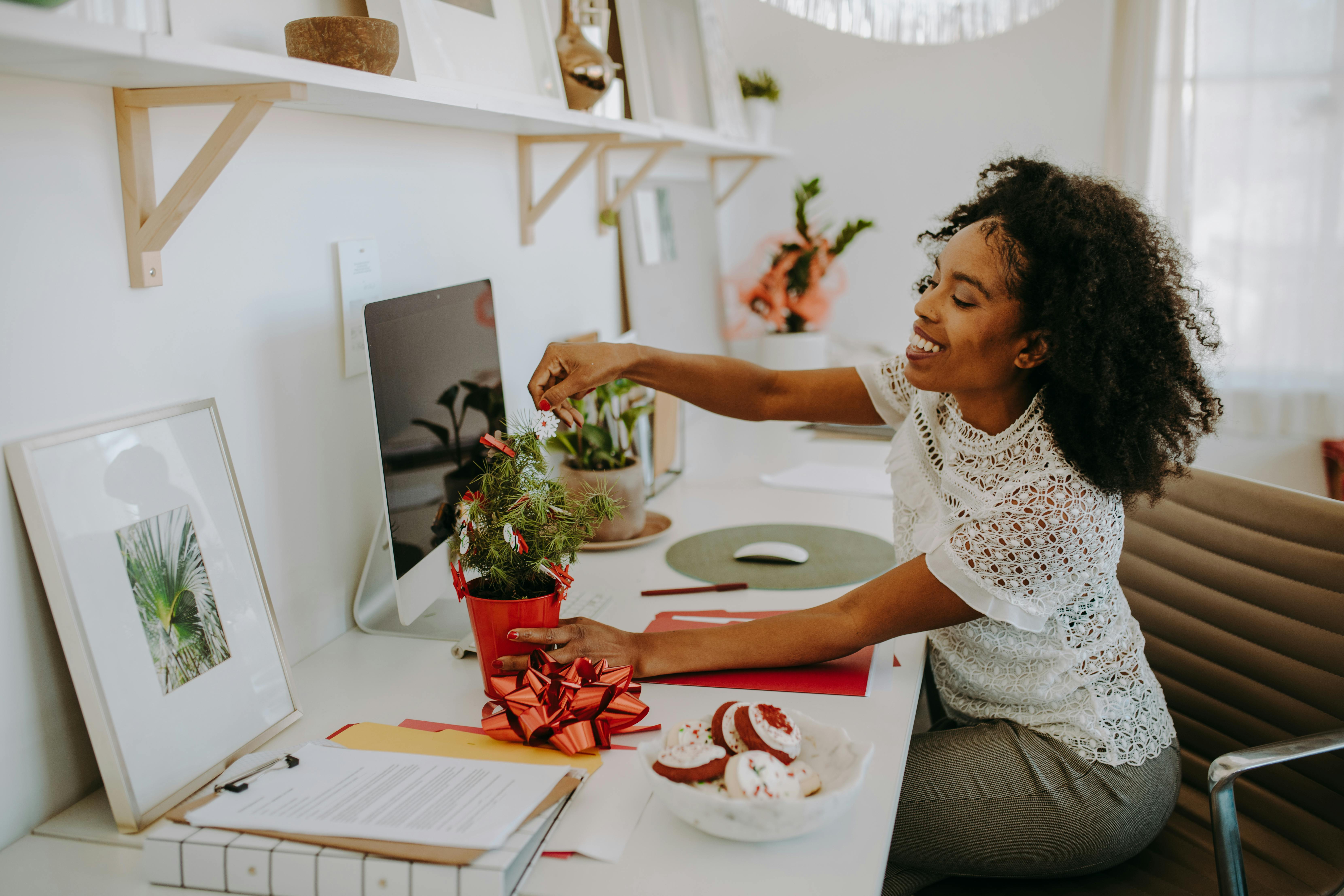 Women adjusting plant on her desk that she received on Christmas