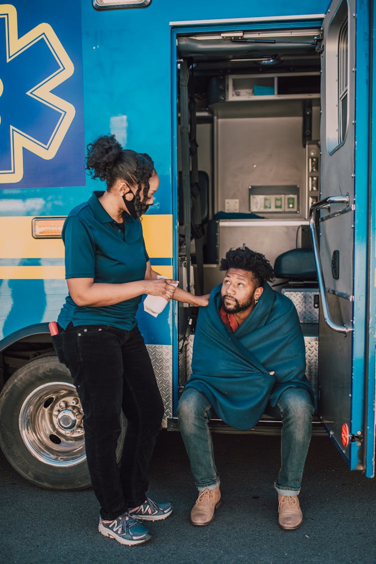 Paramedic Assisting A Man