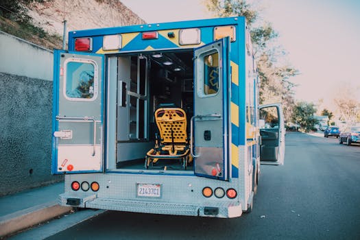 Back view of an open ambulance with a stretcher parked by the roadside.