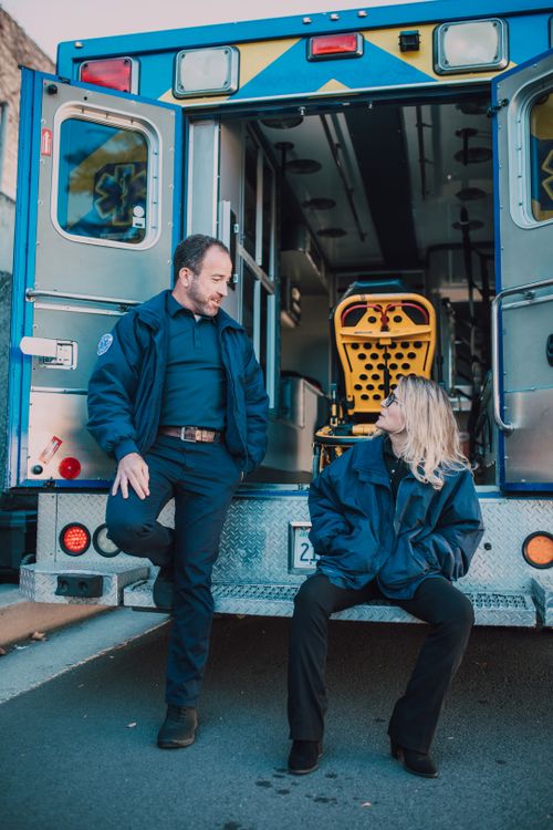 Free Two paramedics taking a break beside their ambulance, ready to respond to emergencies. Stock Photo