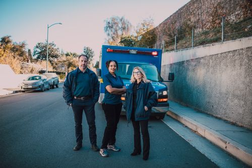 Free A skilled team of EMT professionals stands confidently beside their ambulance outdoors. Stock Photo