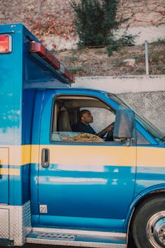 Blue ambulance with a paramedic driving, showing emergency vehicle operation.