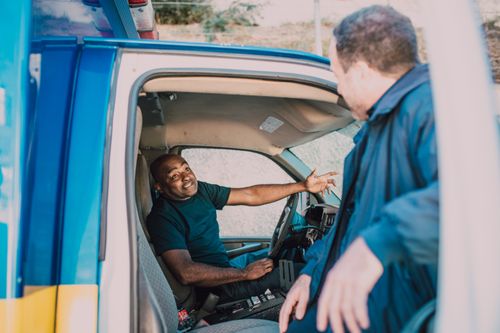 Free Emergency medical technicians engaged in conversation while preparing for duty in an ambulance. Stock Photo