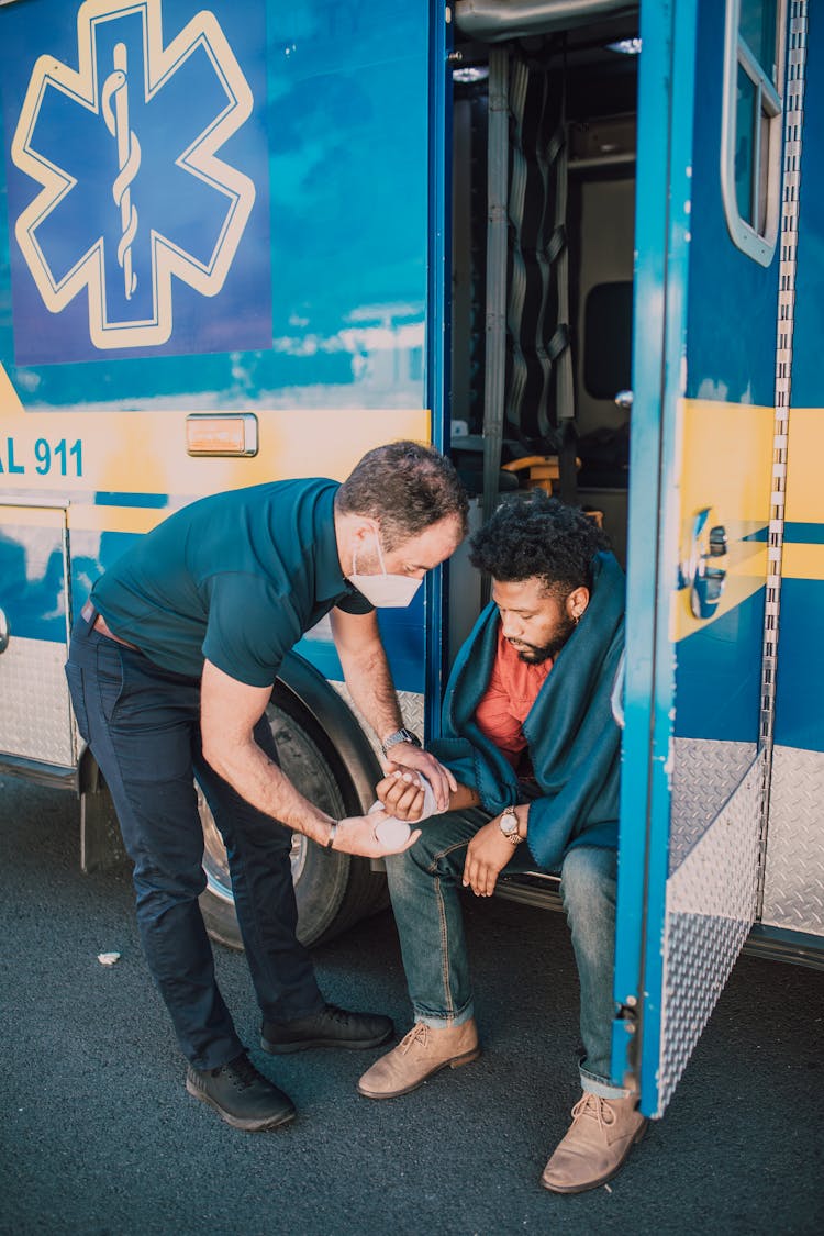 EMT Wrapping Bandage On Man's Arm