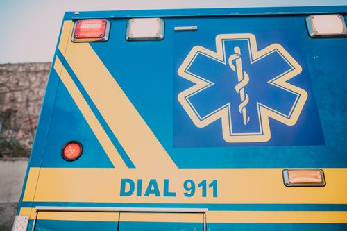 Free Close-up of an ambulance with star of life symbol and 'Dial 911' text. Stock Photo