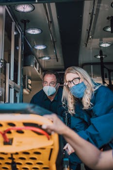 Paramedics prepare a stretcher inside an ambulance for patient care.