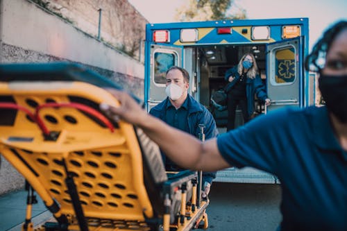 Free Man in Blue Jacket Pushing a Stretcher Stock Photo