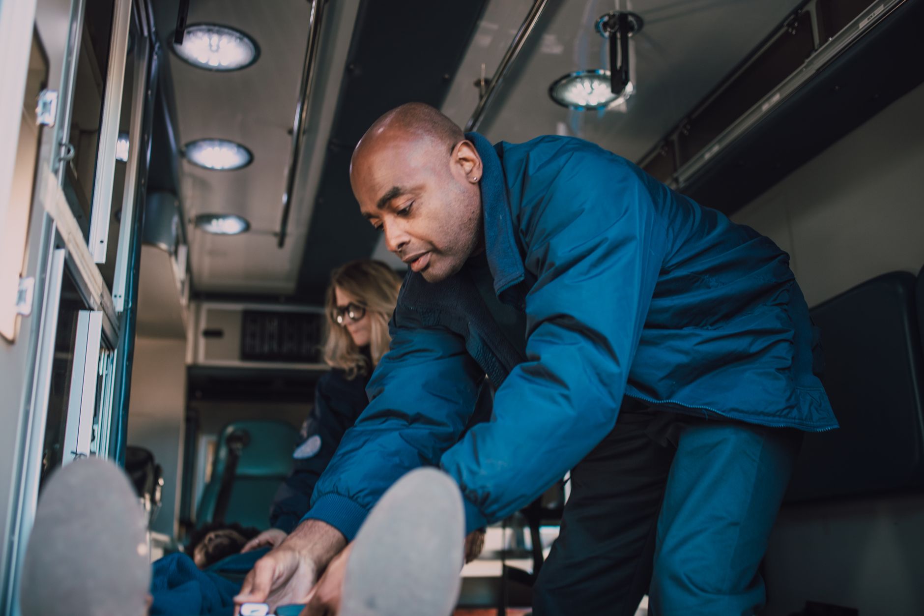 Paramedics attending to a patient inside an ambulance, showcasing emergency medical care.