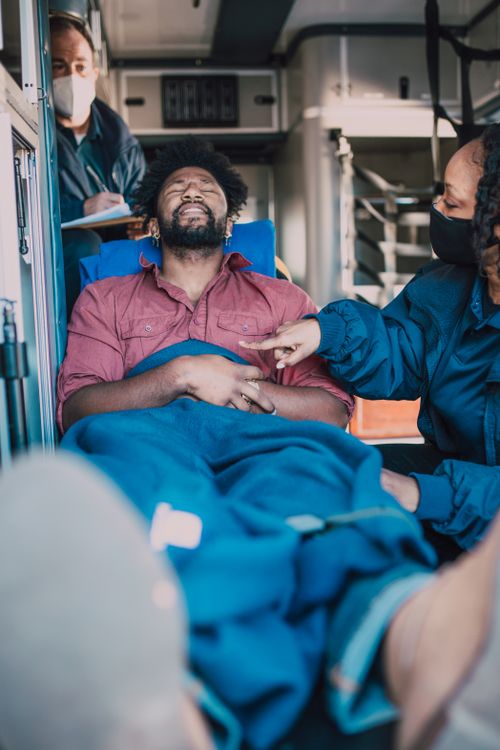 Free Paramedics attend to an injured patient in an ambulance, ensuring his safety and well-being. Stock Photo