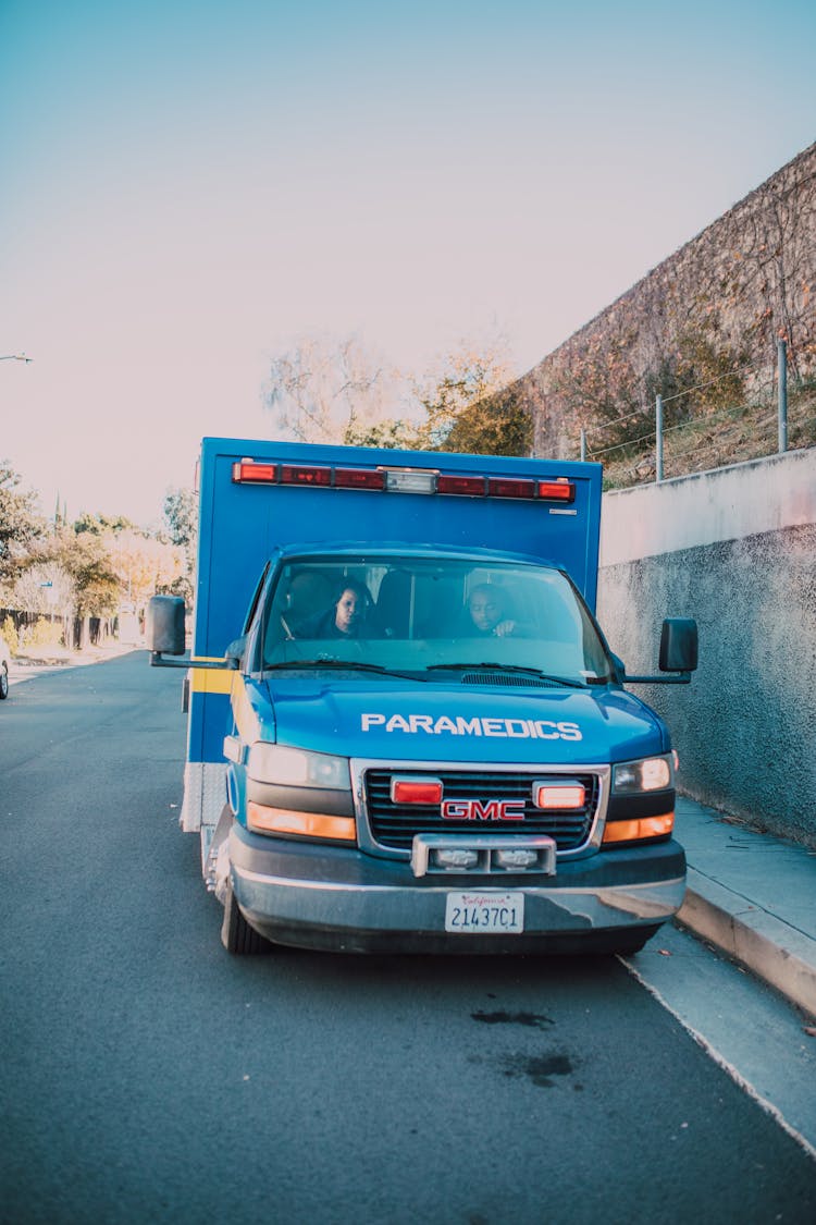 Blue Ambulance Parked On Side Of A Road