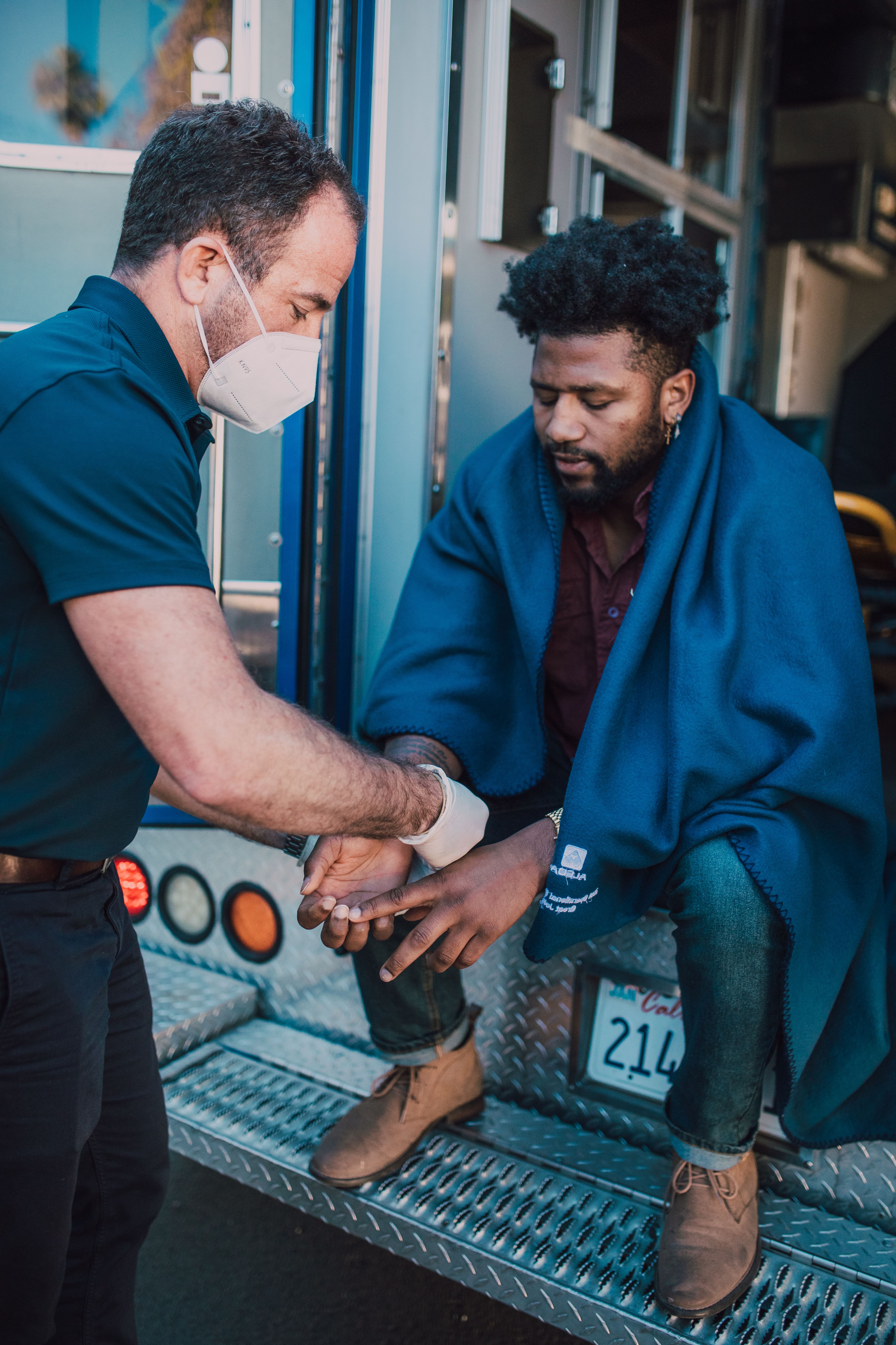 Man in Blue Polo Shirt Helping a Man · Free Stock Photo