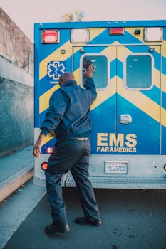Photo by RDNE Stock project A paramedic in action behind an EMS ambulance on a city street during the day.