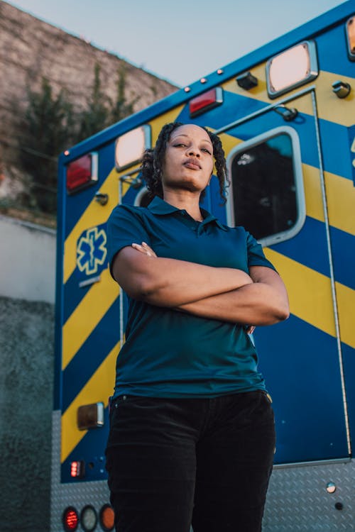 Woman Standing Beside An Ambulance With Arms Crossed