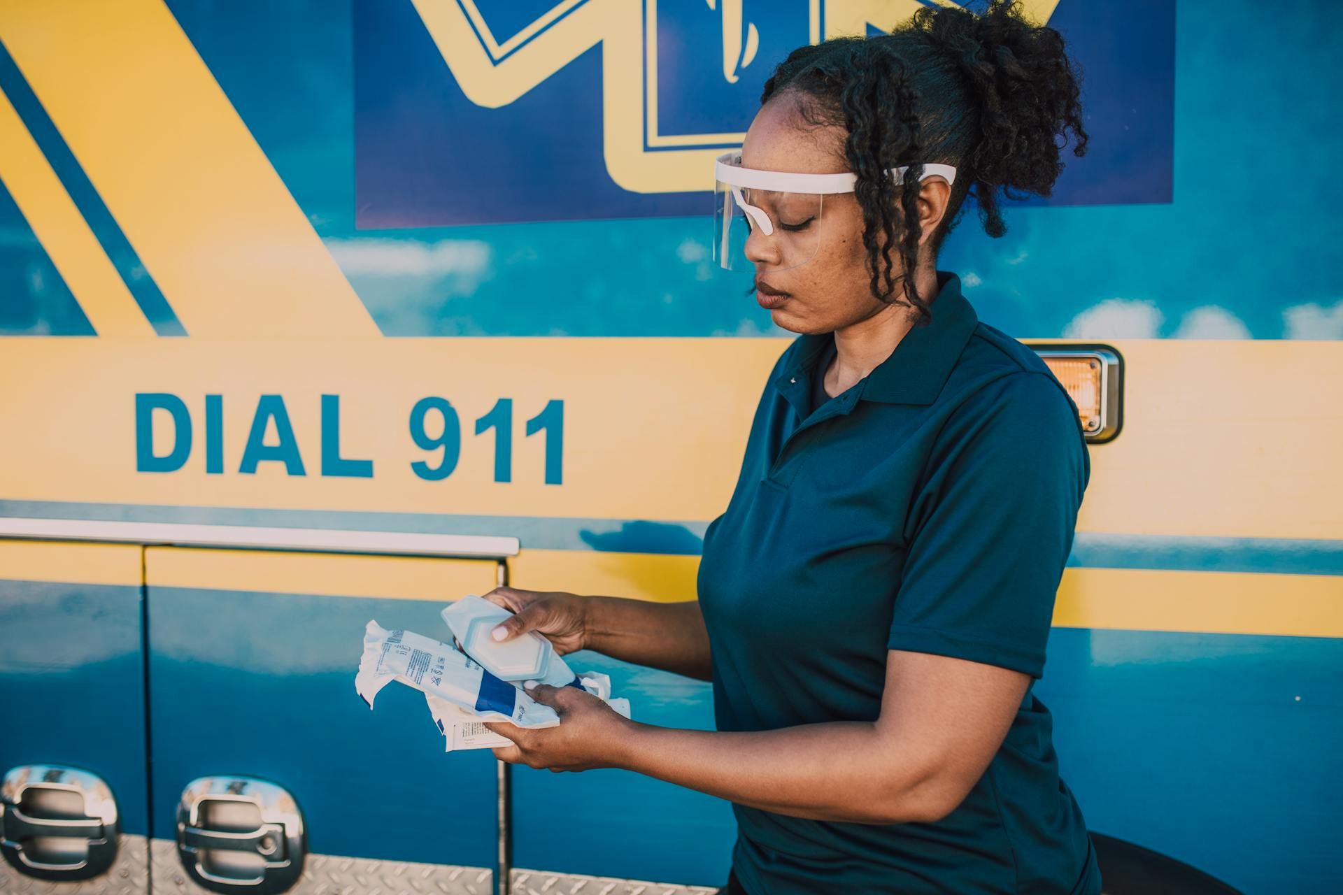 Woman in Blue Polo Shirt Holding Medical Supplies