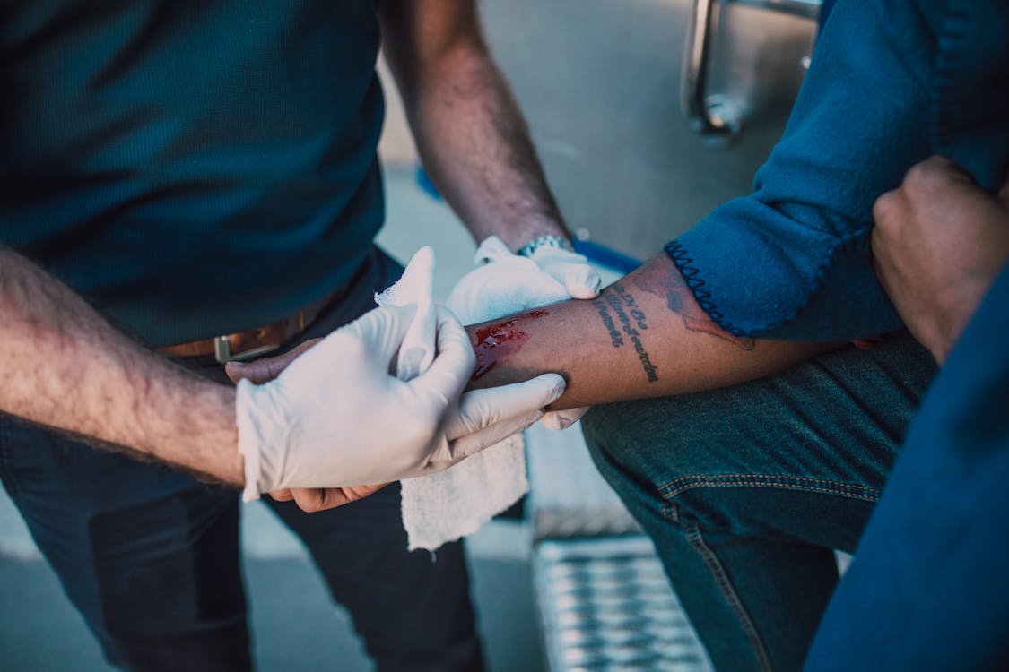 A person is providing first aid to wounded person