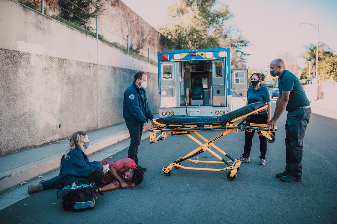 Paramedics helping an injured person after a car accident