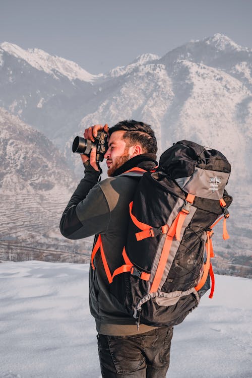 A Male Backpacker Taking Photo Using a Camera