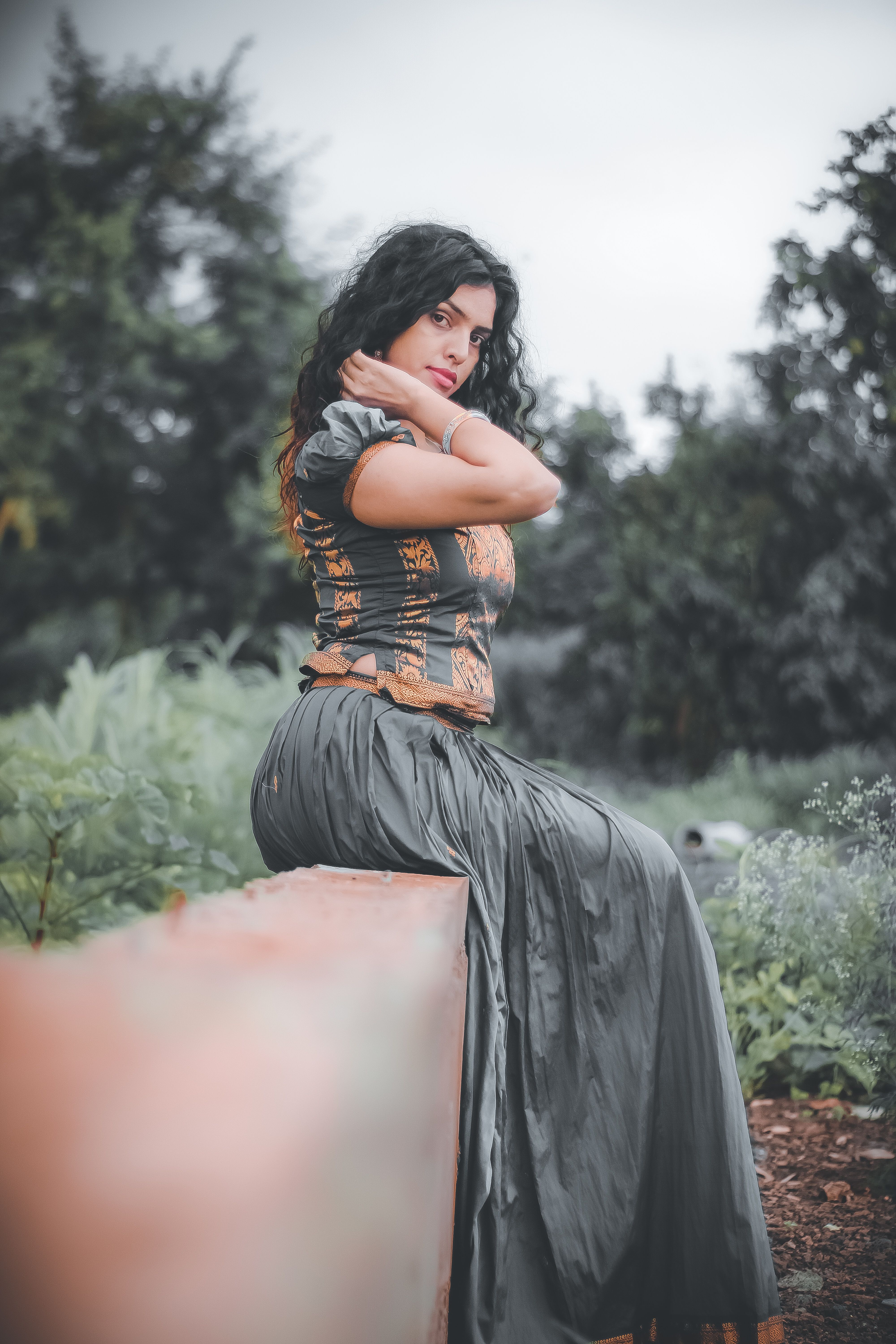 Woman Sitting on the Concrete Fence · Free Stock Photo
