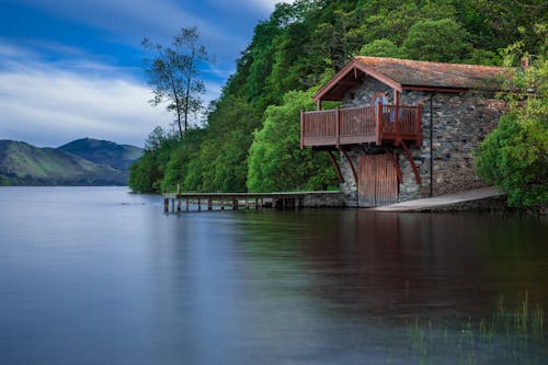 Brown Cottage Near Blue Body of Water during Daytime