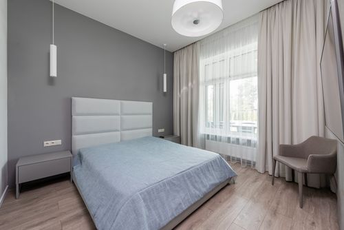 Free Comfortable contemporary interior of spacious bedroom with soft armchair and bed in daytime Stock Photo