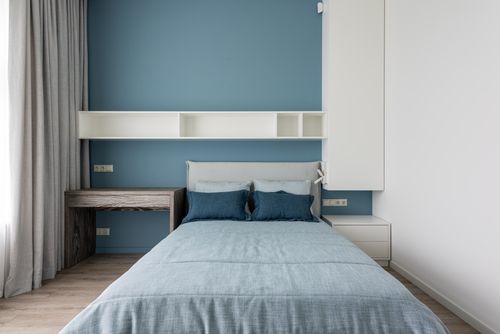Free Contemporary simple interior of bedroom with white shelves and wooden table near window with curtains Stock Photo