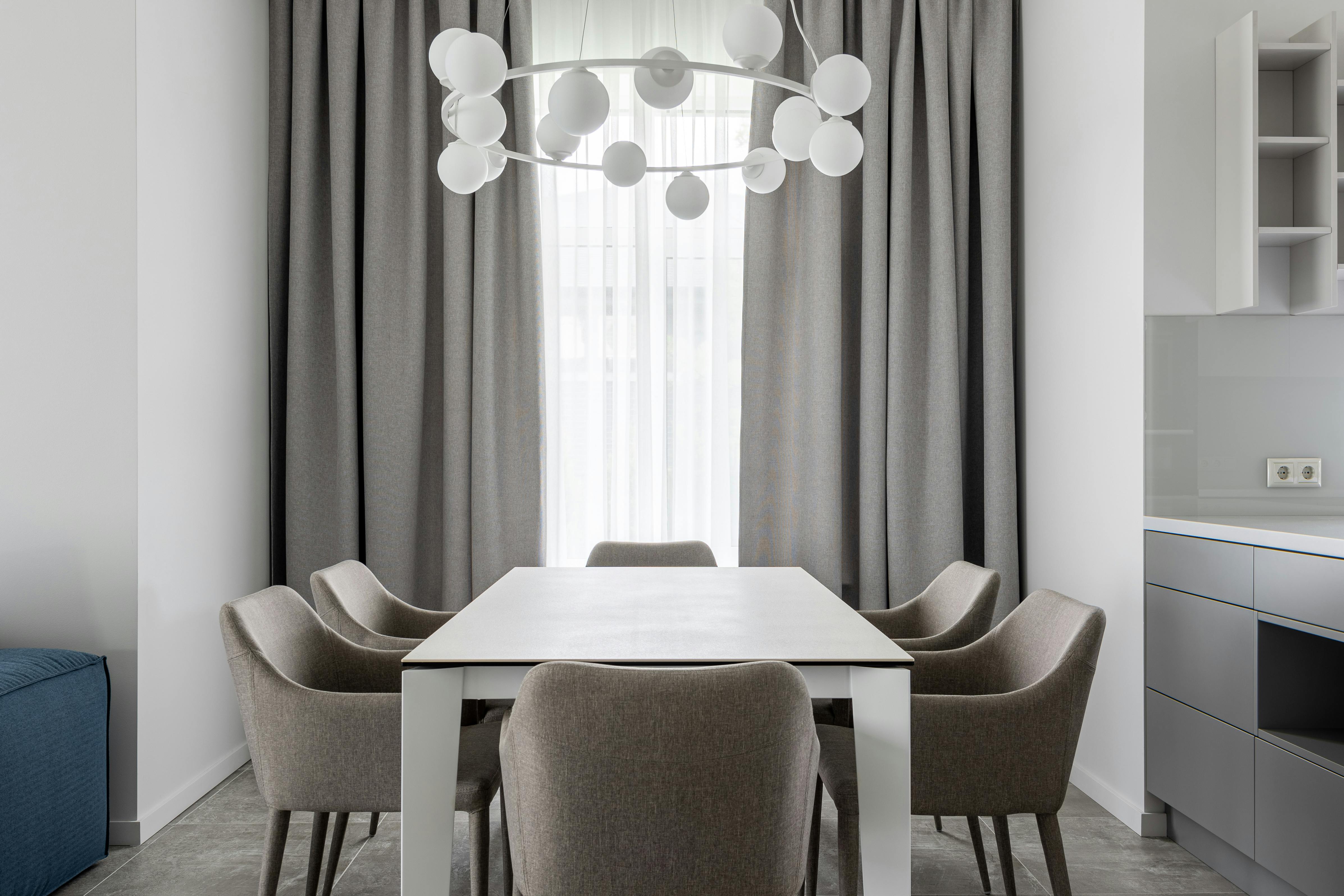 dining room with table and soft chairs under round lamps