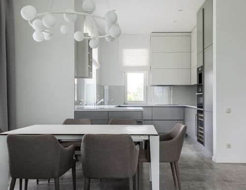 Free Interior of modern comfortable kitchen with clean white table and soft gray chairs Stock Photo
