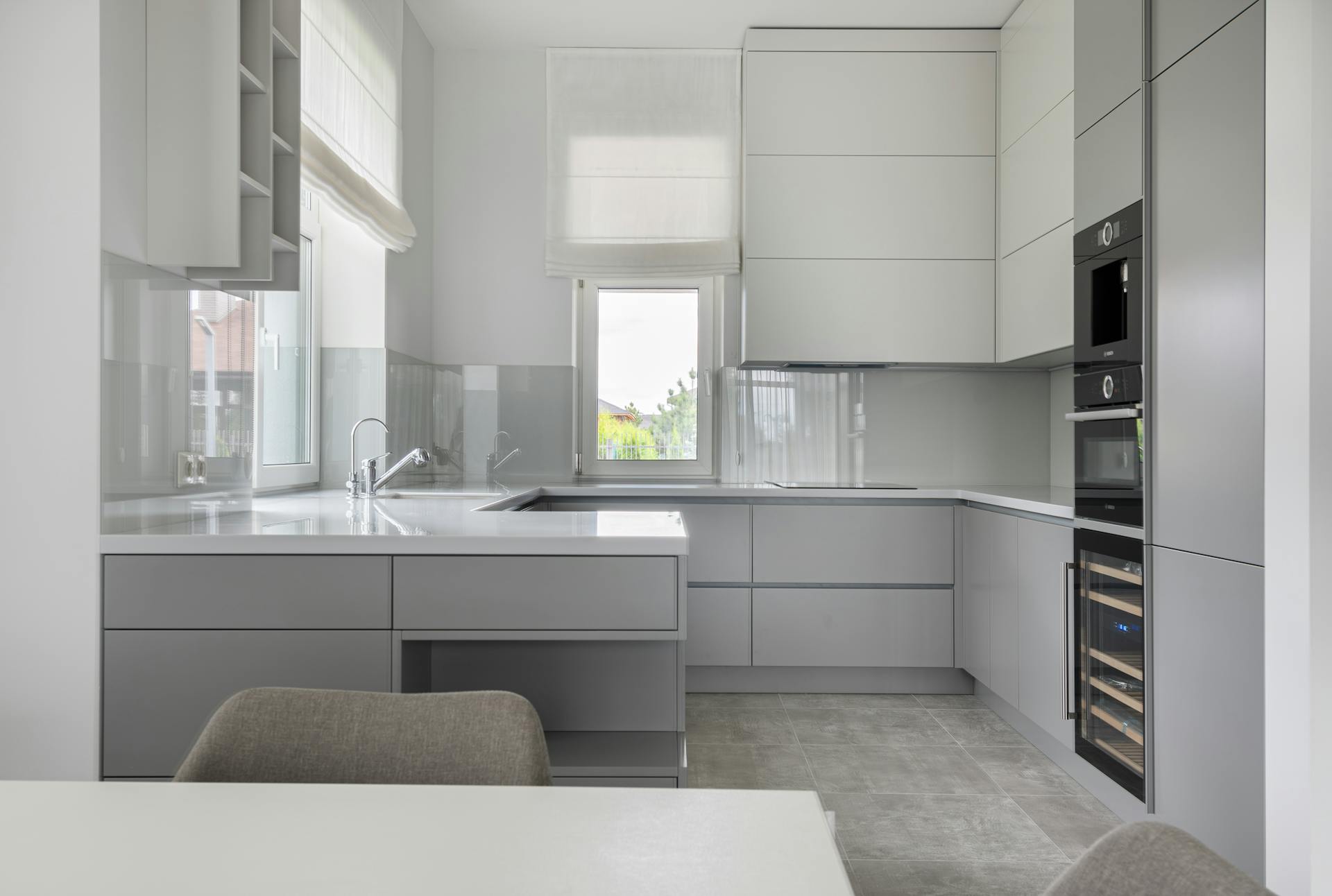 Interior of contemporary new prestige kitchen with modern equipment and white furniture in daylight