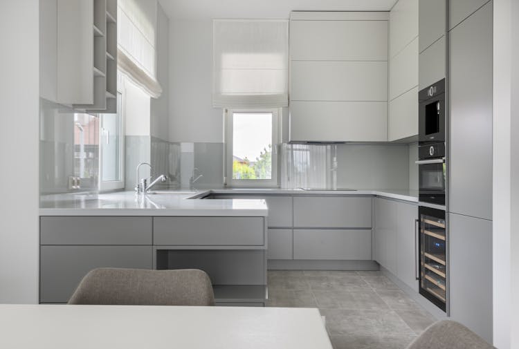 Modern Kitchen With White Cupboards And Table