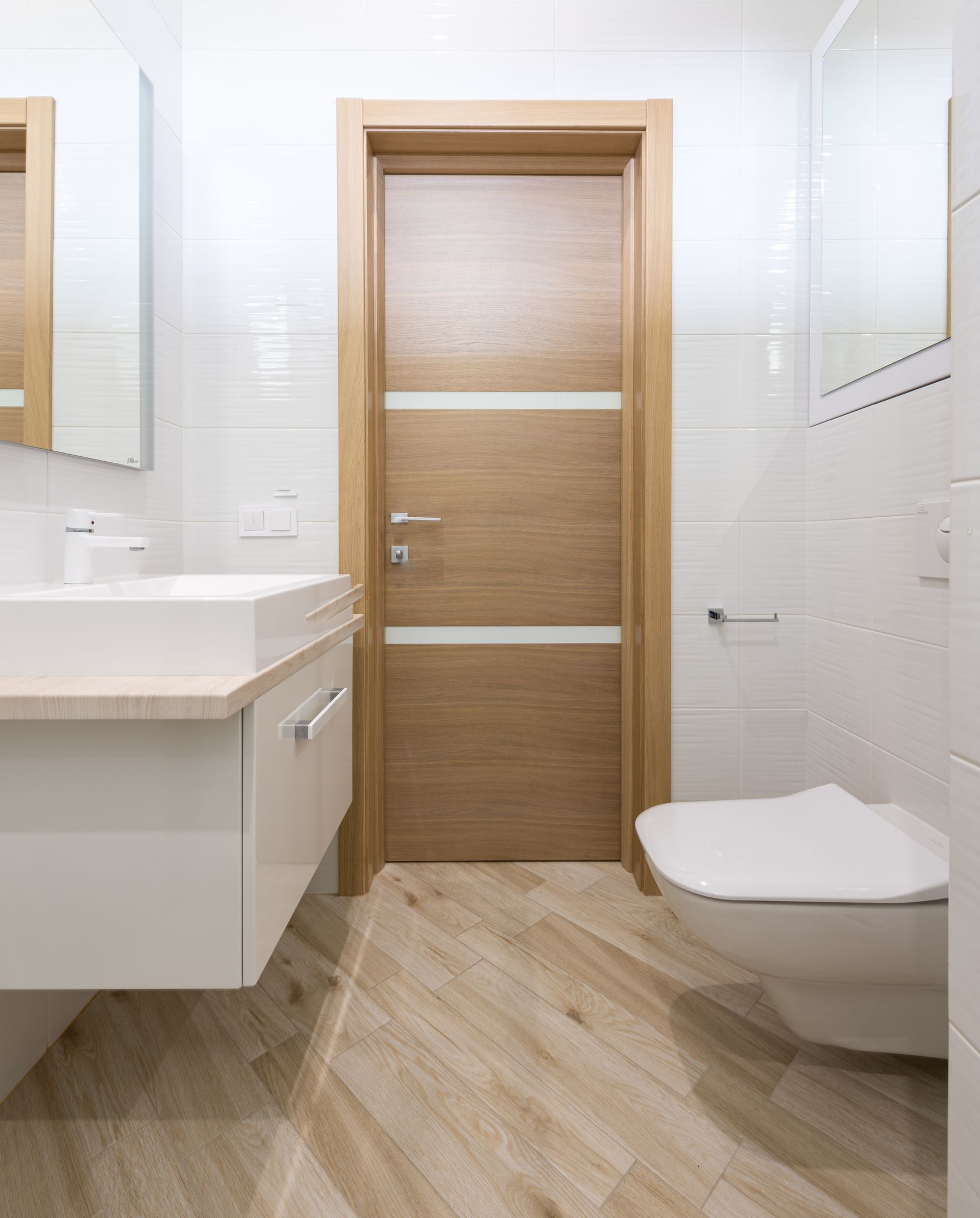 Warm timber bathroom door with simple hardware and a clear entry zone