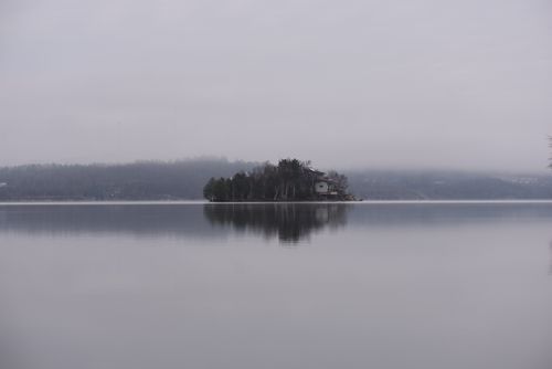Free Serene misty lake with reflective island in Ontario, perfect for tranquil mood settings. Stock Photo