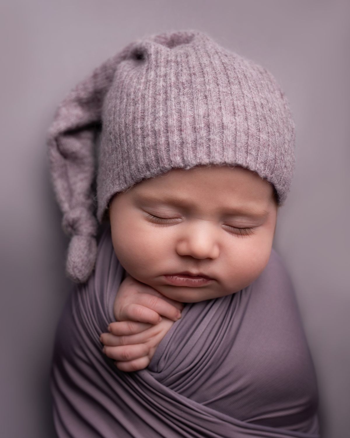 Baby in a gray knit cap portrait for first birthday photoshoot ideas