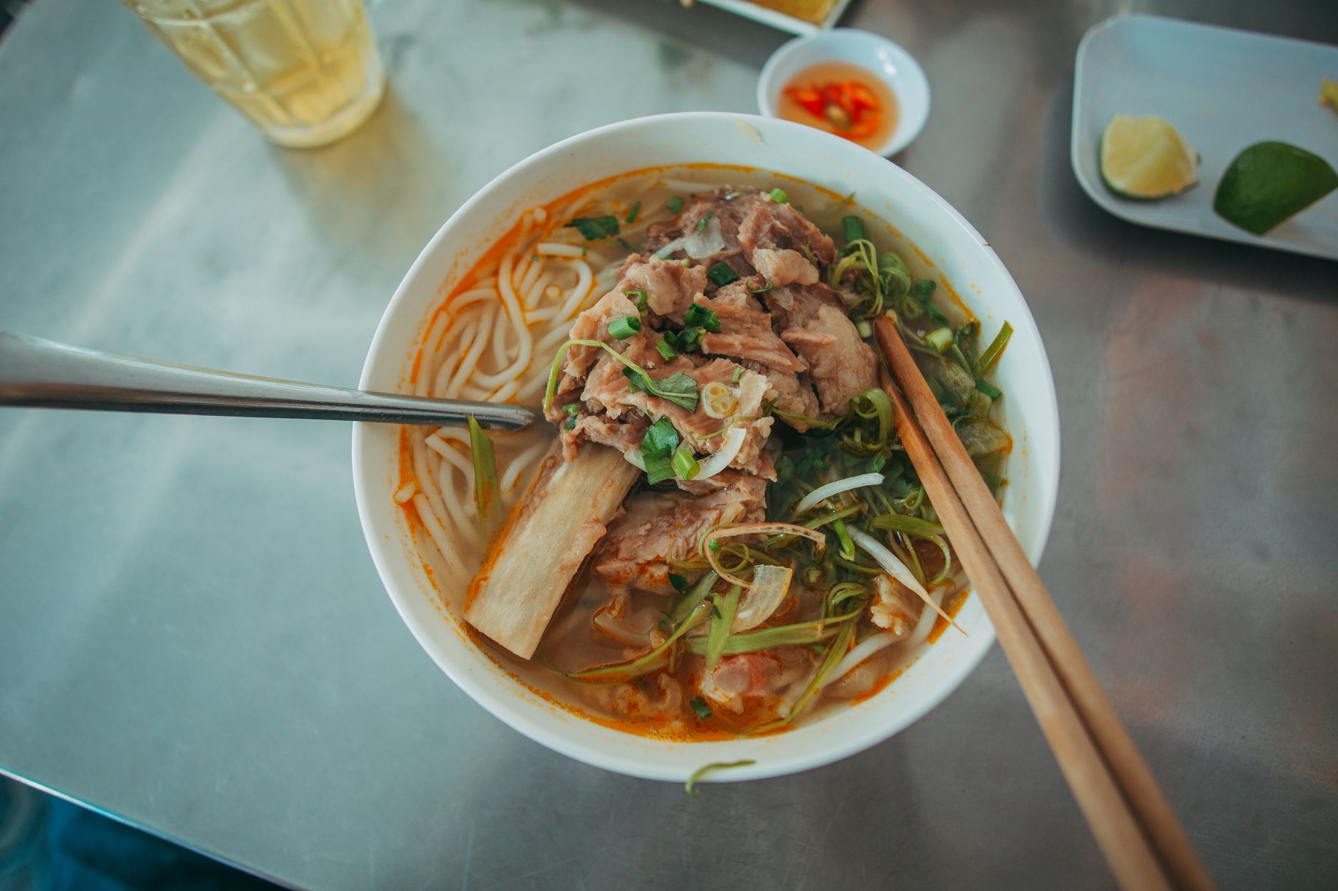 Savor the rich flavors of a Vietnamese noodle soup with pork, served in a bowl with chopsticks.