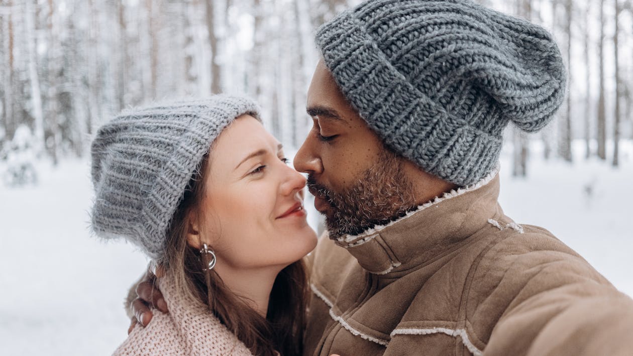 {{https://mixerdates.com/?ch=mixerblog}} A joyful couple embraces outdoors in winter, showcasing warmth and love in a snowy forest