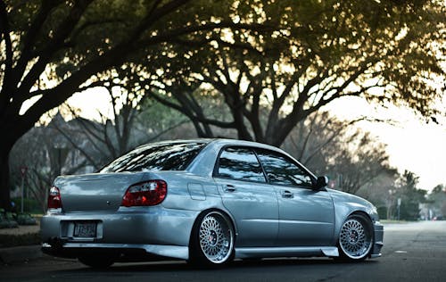 A Gray Car Running on a Road Near Trees