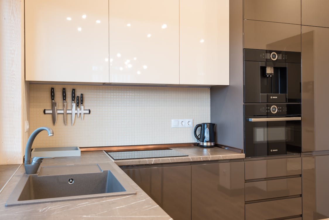 White Wooden Kitchen Cabinet and Stainless Steel Faucet