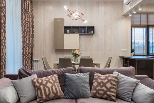 Free Comfortable couch with cushions placed in living room near dining zone in modern apartment Stock Photo