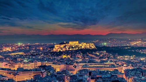 City With High Rise Buildings Under Orange and Blue Sky