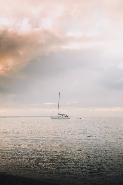 White Boat on Sea Under Cloudy Sky