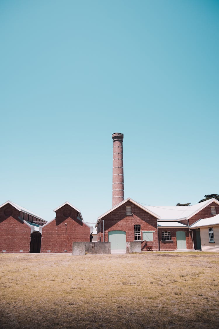 Abandoned Factory And A Chimney Under A Clear Sky 