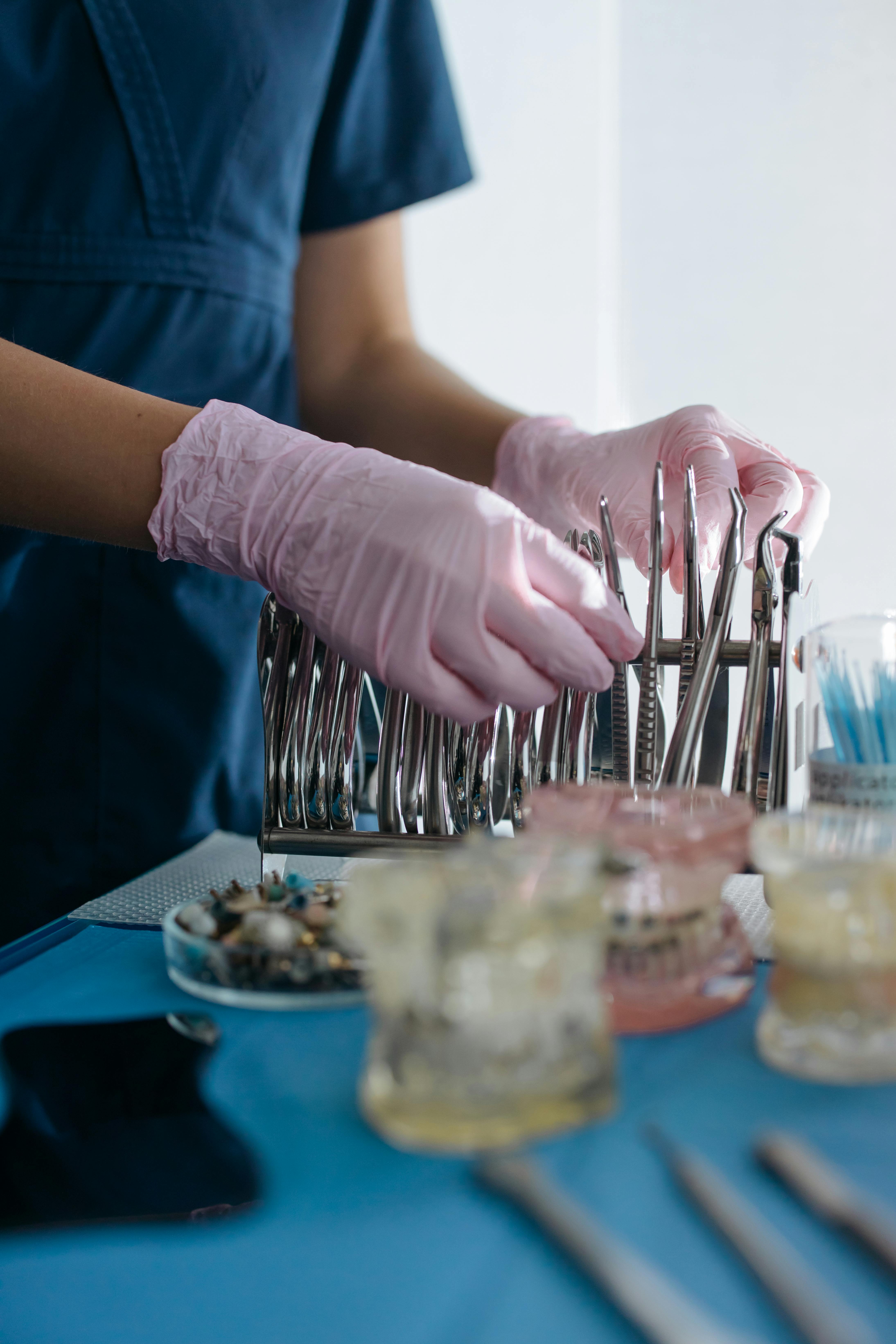 person touching stainless steel dental tools