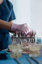 Person in Latex Gloves Touching Steel Dental Instruments