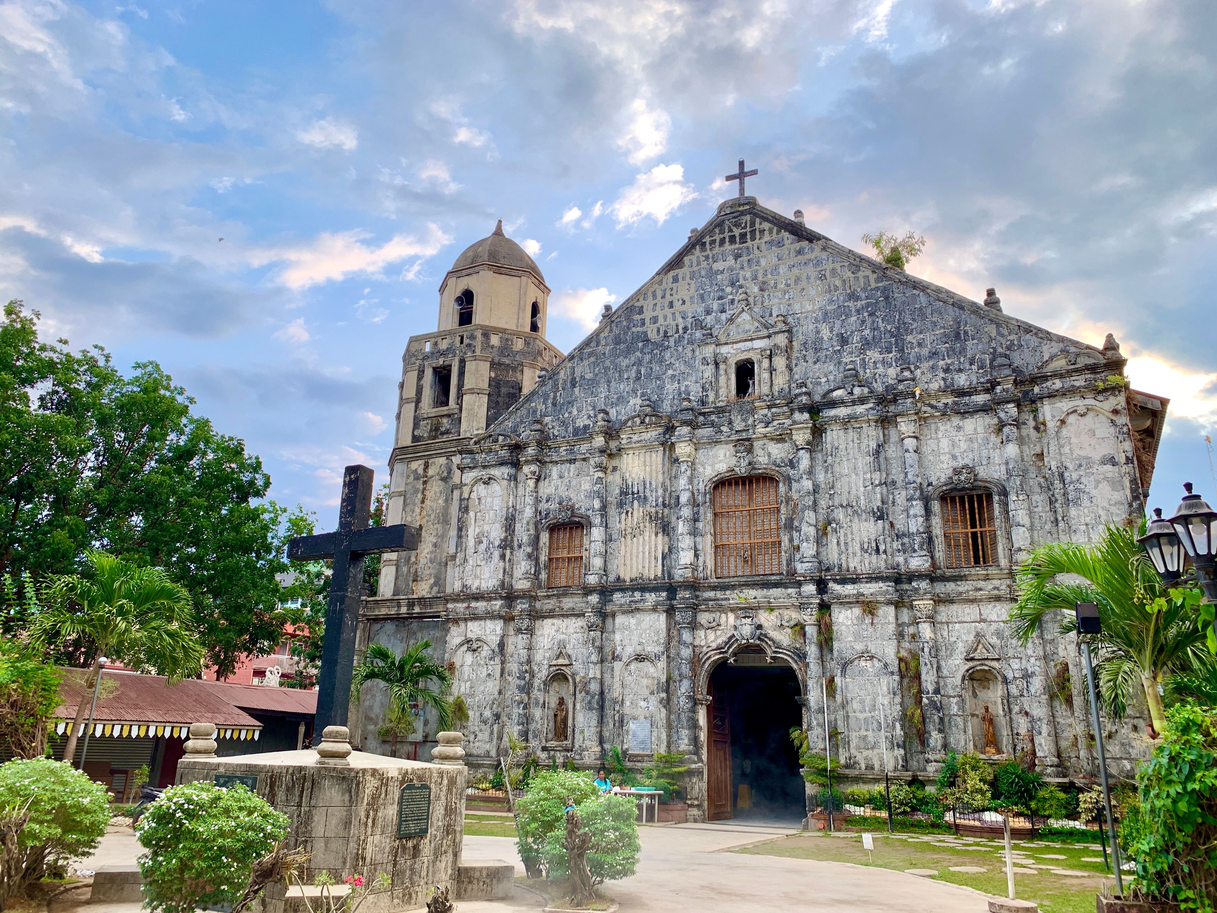 Stunning baroque-style church in Bolinao, showcasing historic architecture amid lush greenery.
