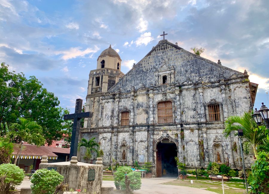 Stunning baroque-style church in Bolinao, showcasing historic architecture amid lush greenery.