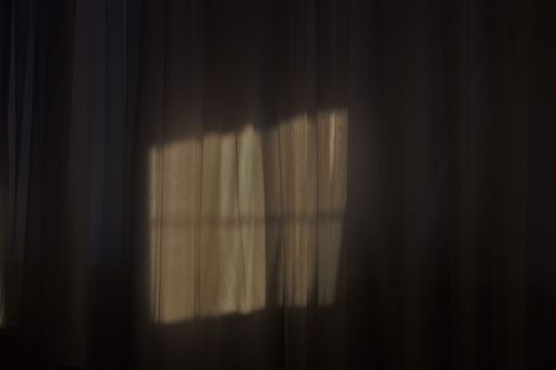 Free Soft sunlight creating abstract shadows on curtains for a serene indoor ambiance. Stock Photo