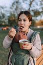 Woman eating a Snack from a Disposable Cup
