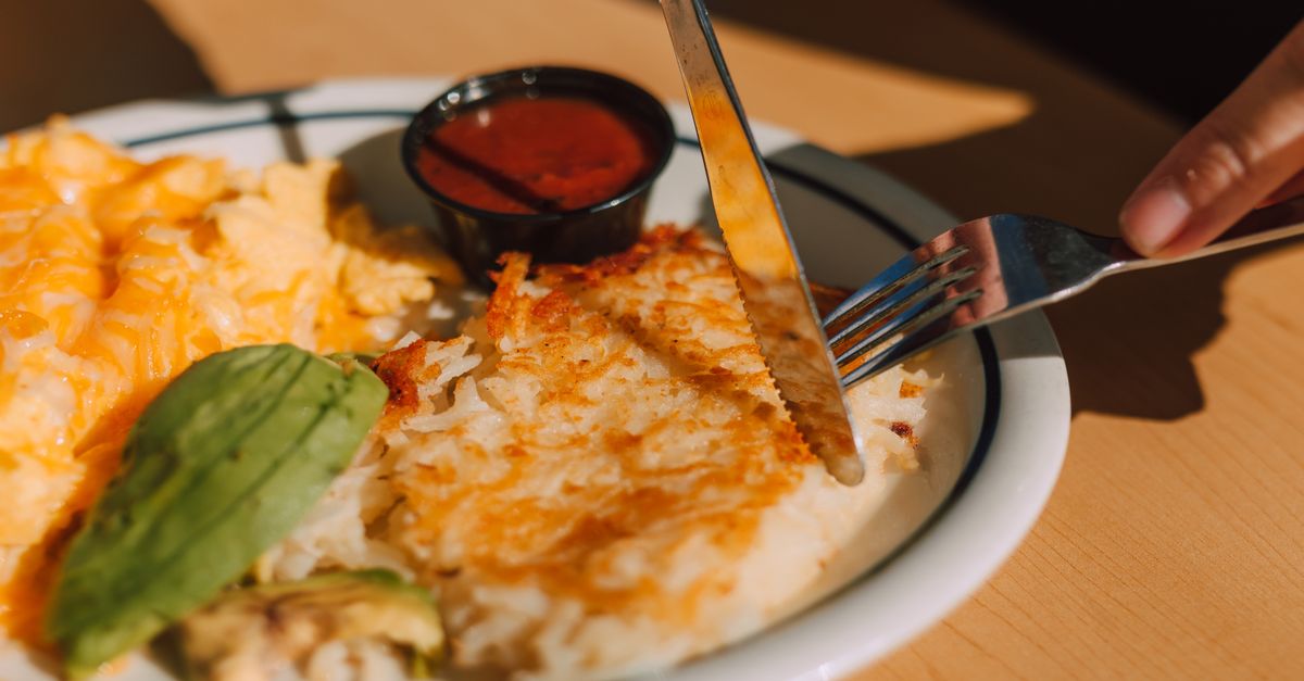 close up of lumpy scrambled eggs on a plate with fork
