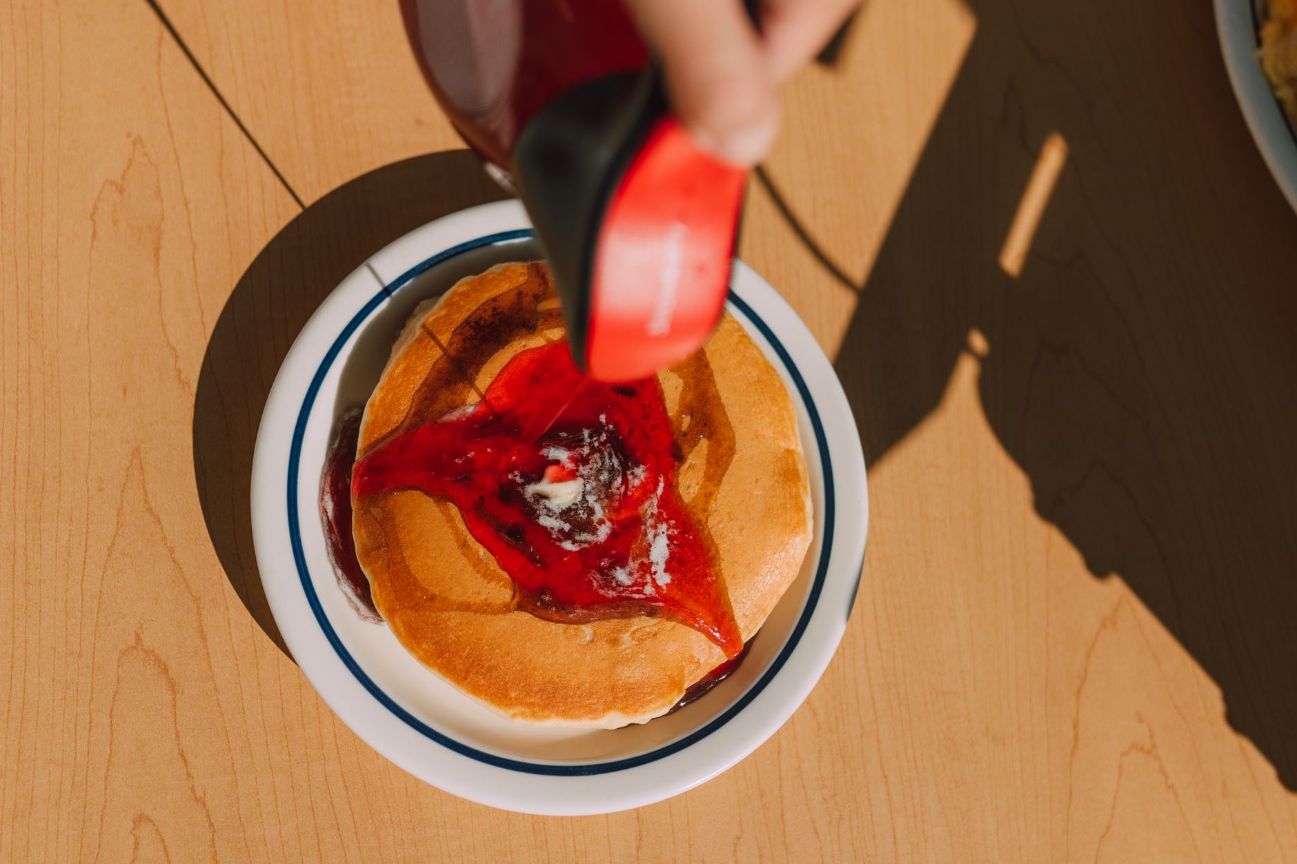 Close-up of fluffy pancakes being drizzled with syrup in a warm Atlanta restaurant