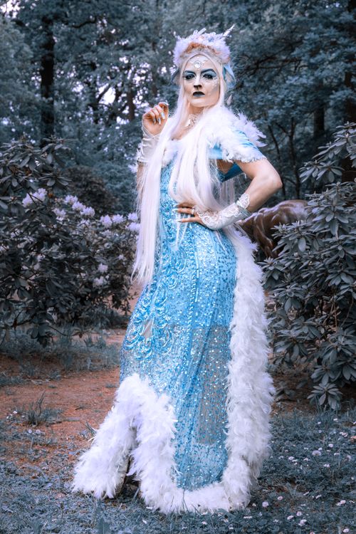Free Elegant woman in blue fantasy costume posing outdoors in lush forest. Stock Photo